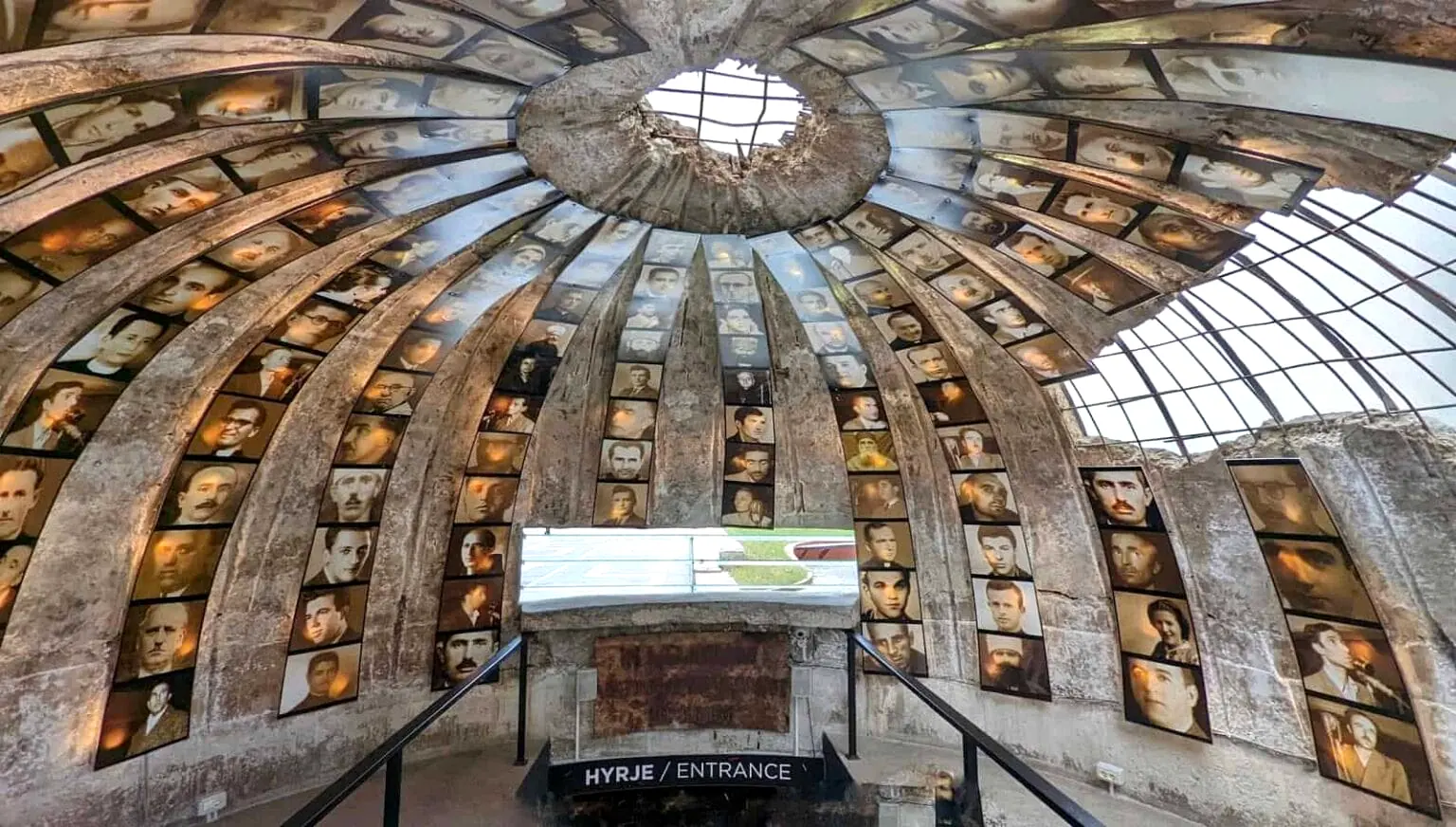 Interior entrance of Bunk'Art 2 Museum in Tirana, Albania, featuring a concrete dome lined with portraits commemorating victims of communist persecution