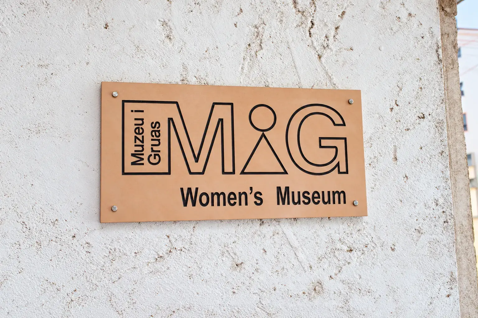 Muzeu i Gruas Women's Museum sign mounted on a textured white wall in Tirana, Albania